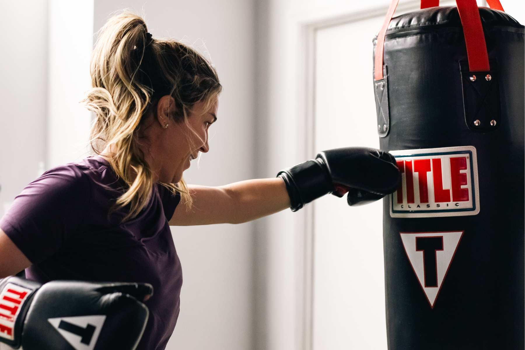 Member mid-punch during an intense cardio boxing round at No Doubt Fitness