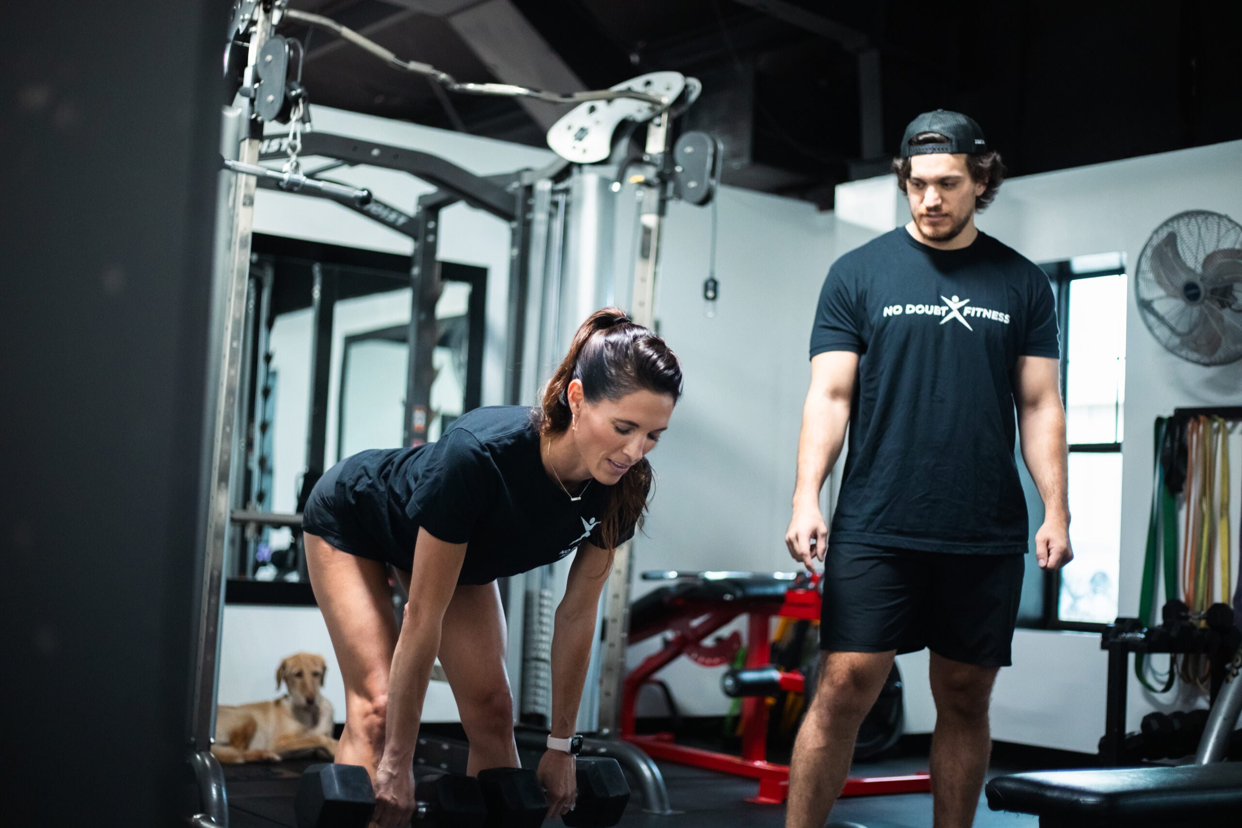 Personal trainer working with client on strength training in a private room