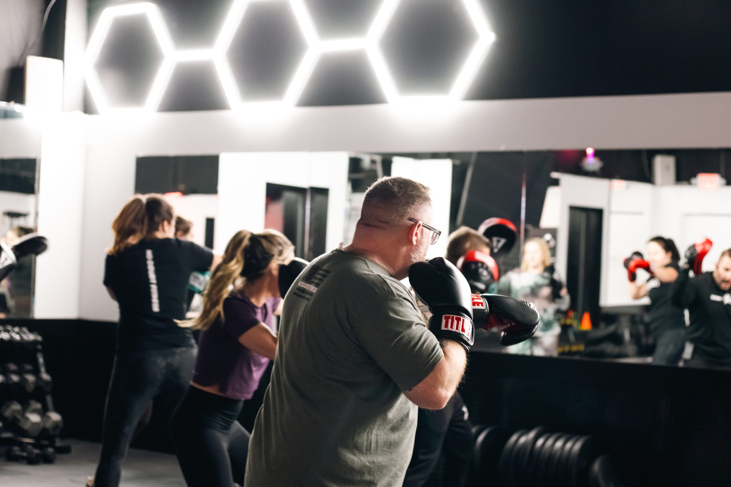 Member throwing combinations on a heavy bag during a cardio boxing session