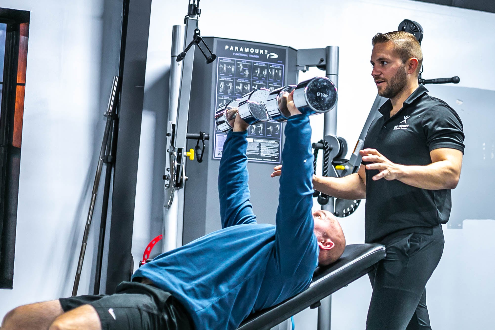 Coach correcting form during a personal training session at No Doubt Fitness